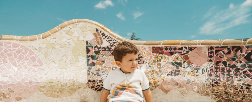 Petit garçon assis sur le banc du parc güell à Barcelone. Représente le travail d'un psychologue pour enfants à Barcelone