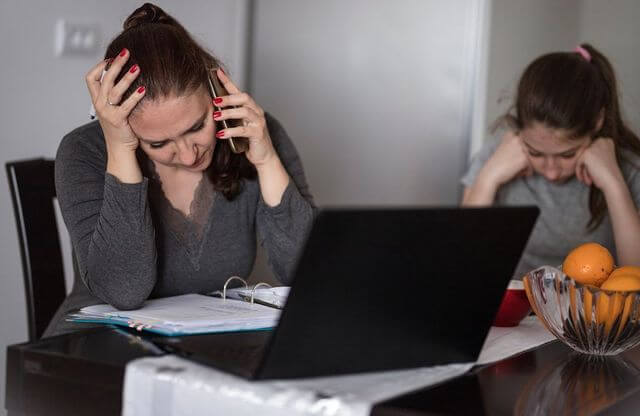 Photo d'une mère qui téléphone et sa fille à côté qui présente un faciès triste. Cette image représente l'aide que peut apporter un psychologue face au harcèlement scolaire